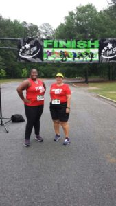 2 women, 1 african american 1 white at road race finish line