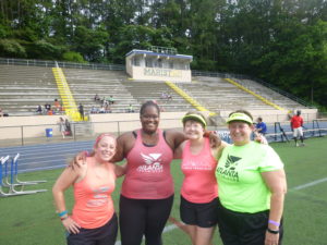 4 women in running clothes at track meet